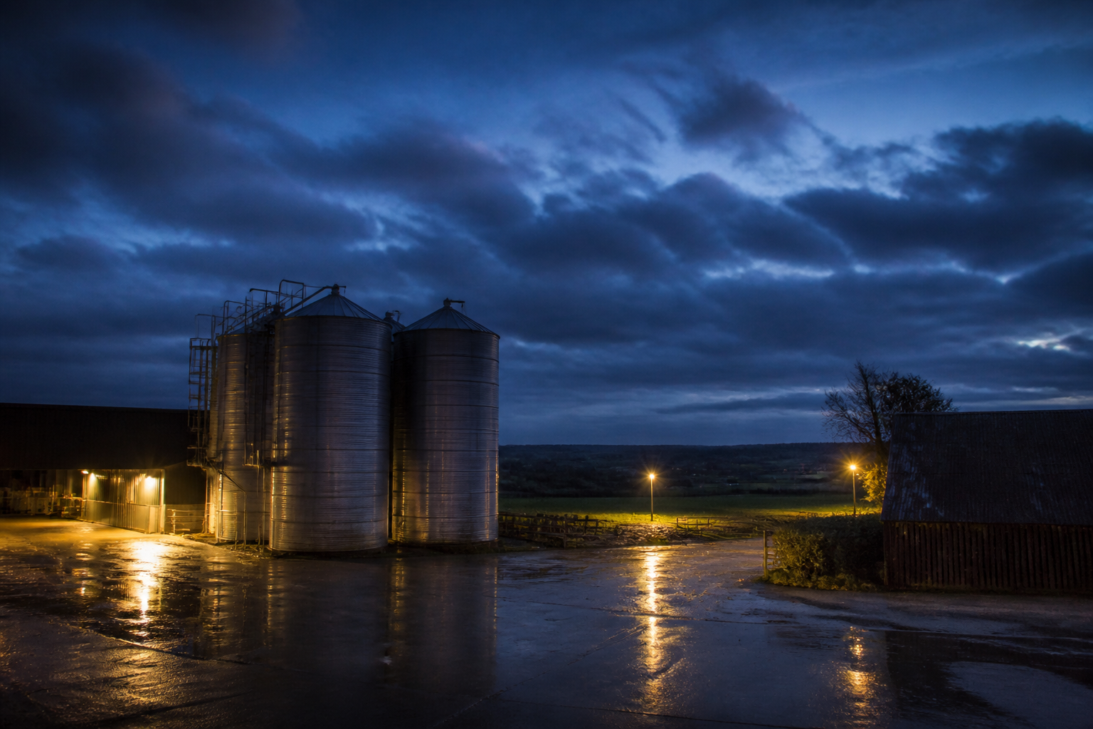 Farm buildings and grain silos at dusk